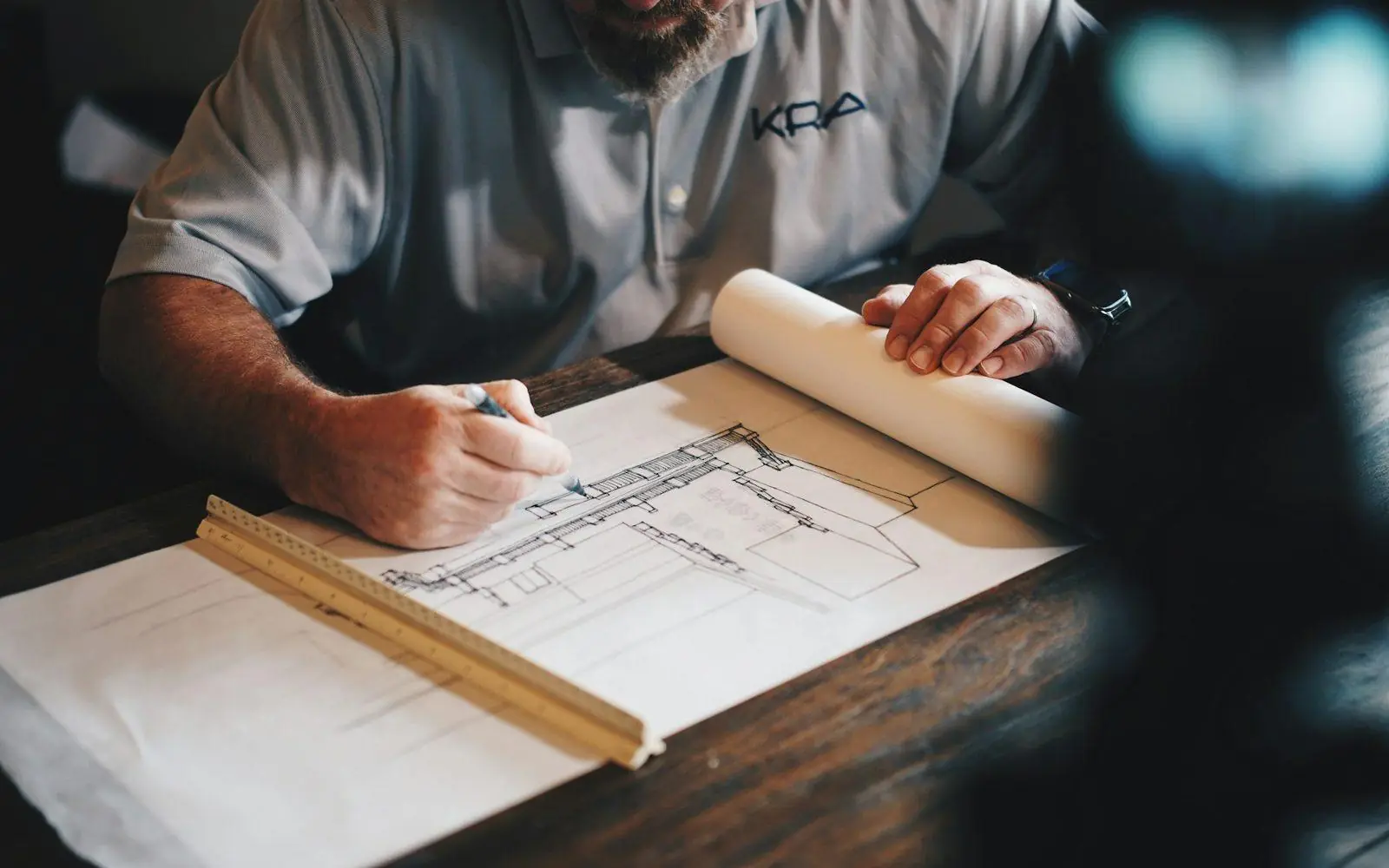 Hands drafting plans on a drawing table