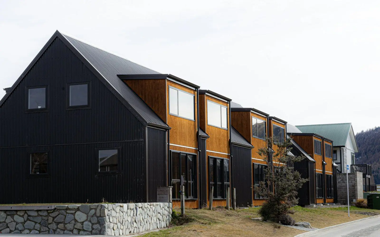 New black-clad townhouses along a residential street